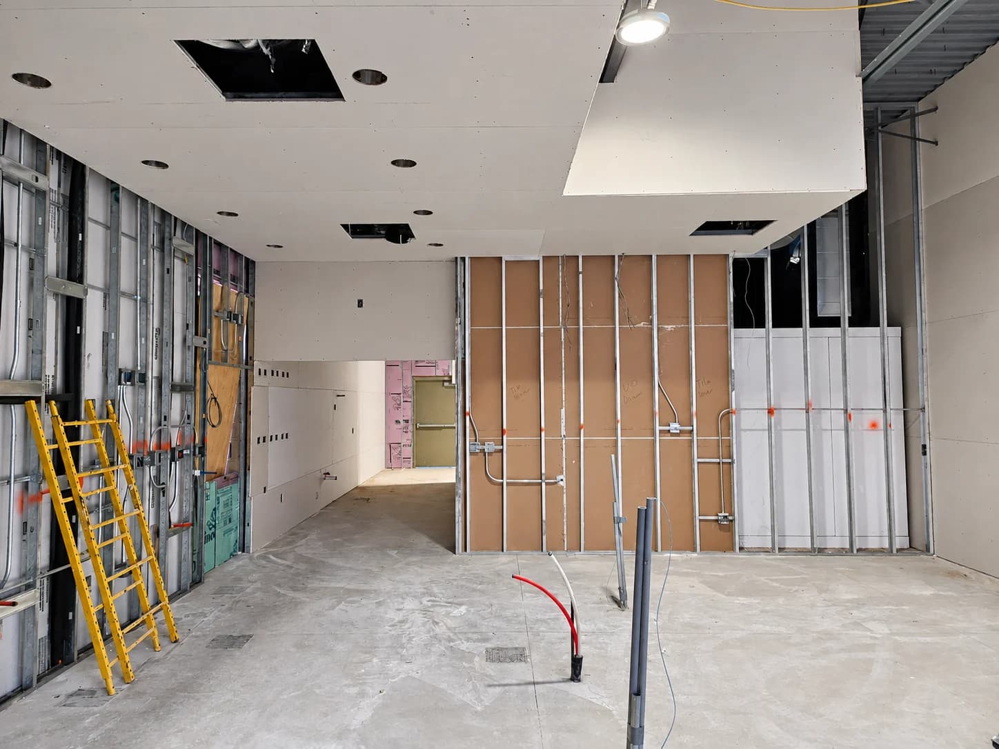 Installed ceiling drywall above partially boarded metal-stud partitions